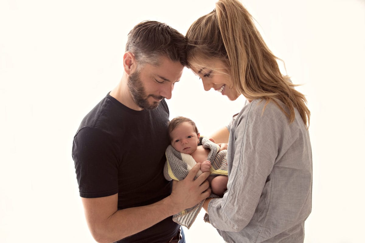 Mutter und Vater halten zusammen ein Baby bei einem Familienfoto im Carmen Bergmann Studio