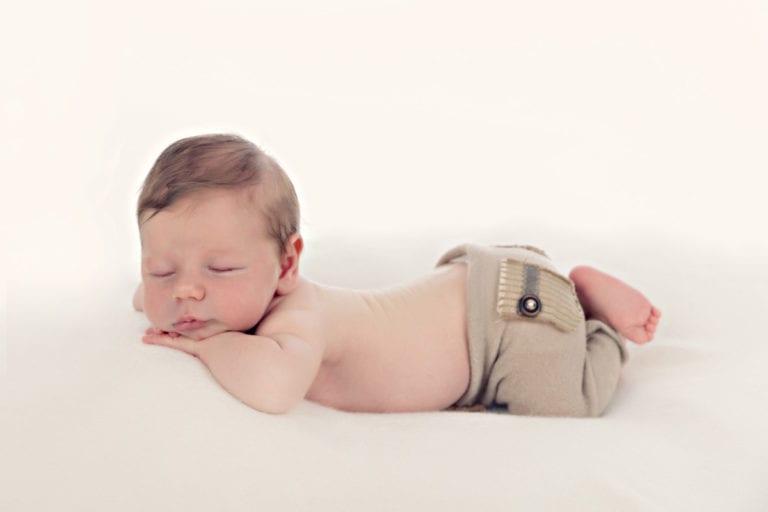 Neugeborenes Baby schlaeft auf dem Bauch in Carmen Bergmann Fotostudio in Muenchen Bergmann