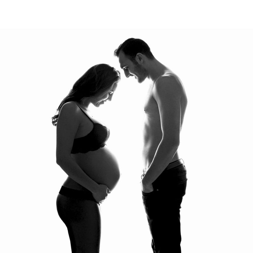 Schwangere Frau mit ihrem Mann beim Babybauch Shooting