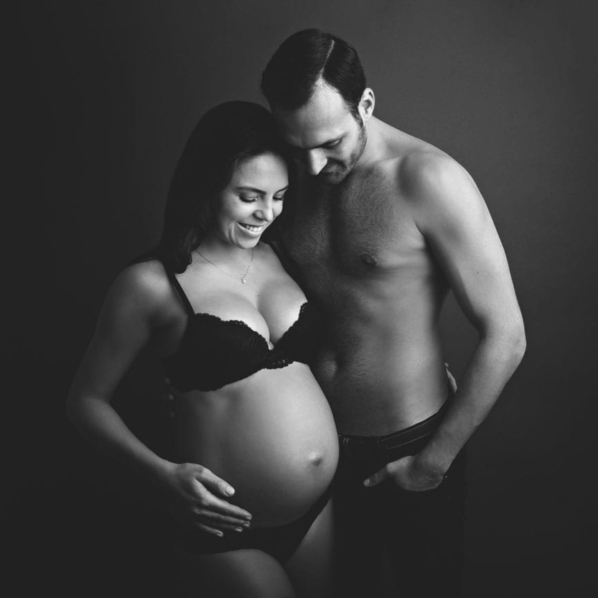 Schwangere und Mann posieren fuer Babybauch Fotos in Carmen Bergmann Fotostudio fuer Schwangerschaftsfotografie