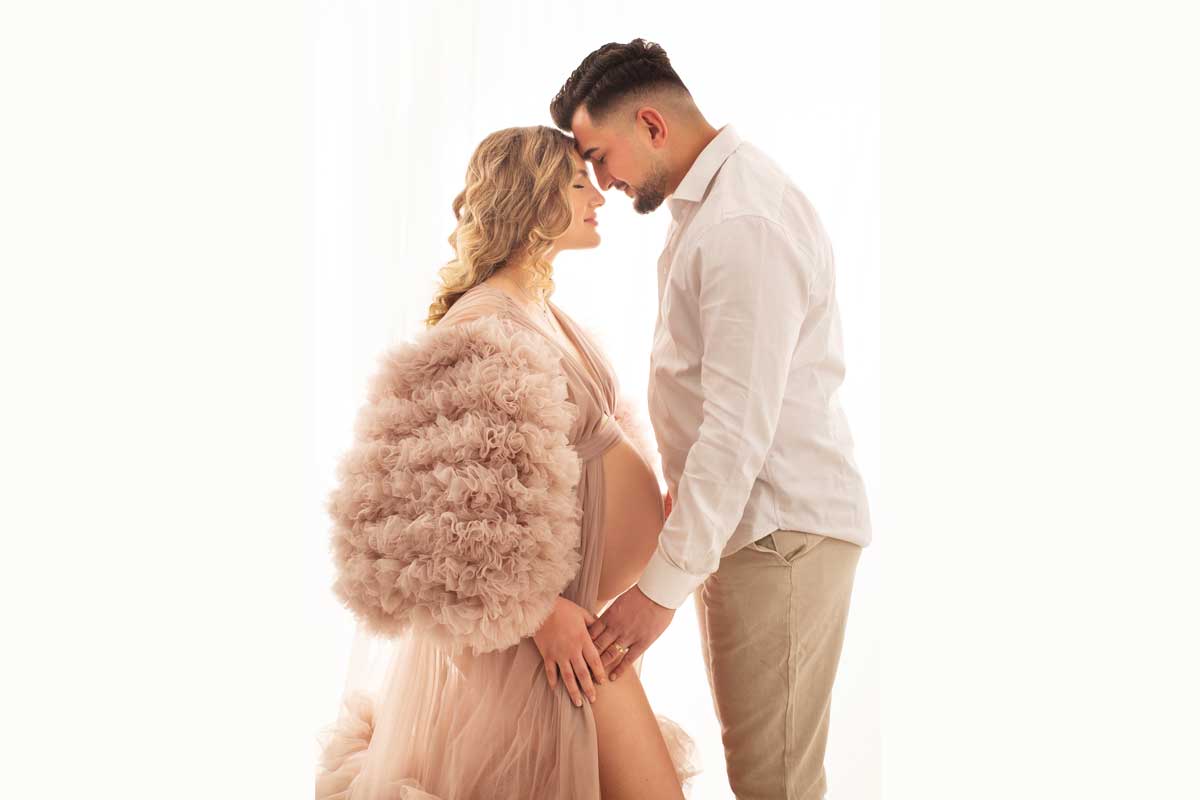 schwanger-in-einem-braunen-Kleid-mit-ihrem-Mann-bei-einem-Schwangerschaftsfoto-Shooting-in-Muenchen
