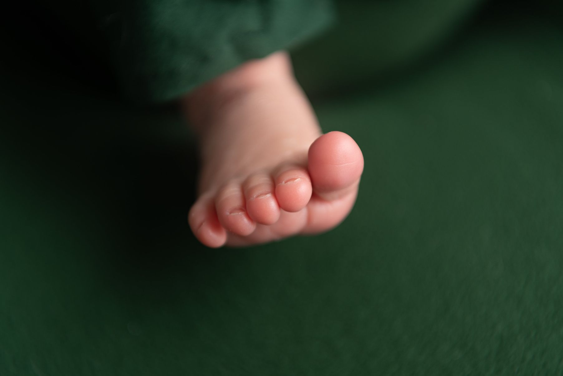 Babyshooting Fuß grüner Hintergrund