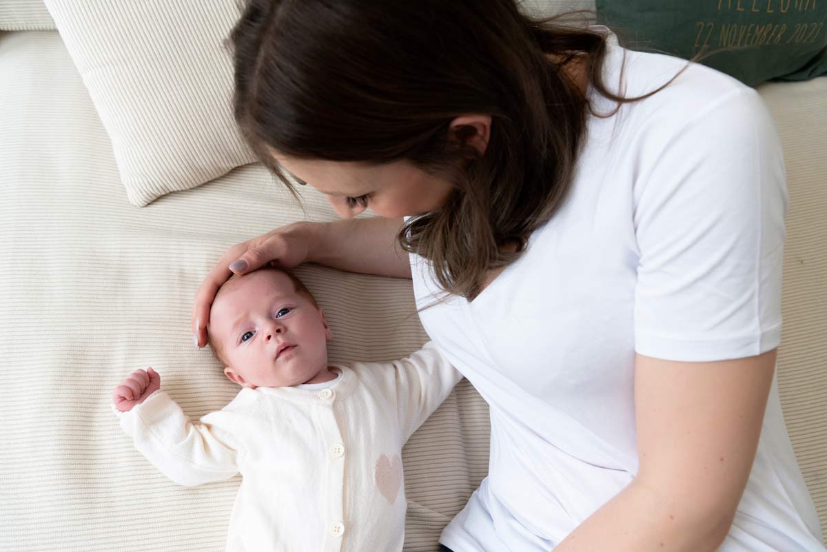 Baby-zusammen-mit-Mama-beim-Neugeborenen-Fotoshooting-zu-Hause-in-Muenchen